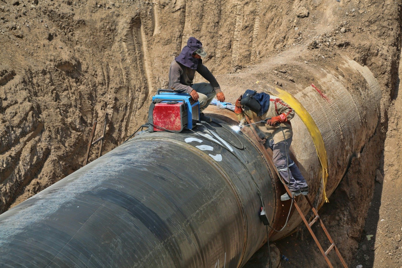 Welder joining rebar mesh on a foundation